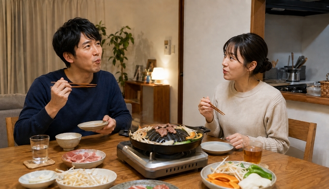 卓上グリルで焼いたマトンを一人が口にし、もう一人がその反応を見ている。