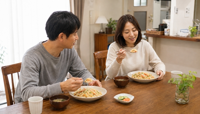 翌日の食卓で、カニを使った炒飯を二人で食べている様子。